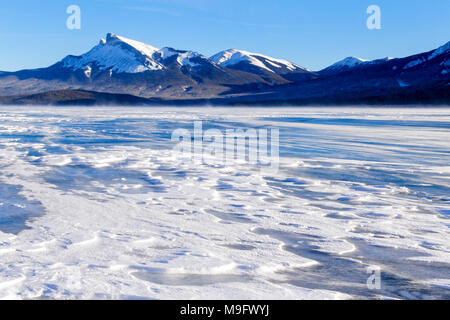 42,747.08360 inverno freddo e neve paesaggio innevato spazzato il lago di Abramo, congelati blue ice lake, montagne sullo sfondo, Nordegg, Alberta Canada, America del Nord Foto Stock