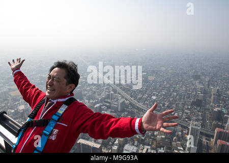 Osaka, Giappone. 26 Mar, 2018. Un uomo che indossa cavi di sicurezza pongono al top della nazione L'edificio più alto di 300-metro-tall Abeno Harukas di Osaka il 26 marzo 2018. Il bordo Harukas, un attrazione offre alle persone la possibilità di vivere una emozionante vista salendo su una 20-metro-lungo circa 60 centimetri di-ampio ponte in corrispondenza della sommità dell'edificio. (Foto: Richard Atrero de Guzman/AFLO) Credito: Aflo Co. Ltd./Alamy Live News Foto Stock