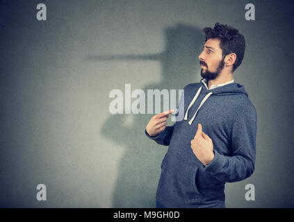 Vista laterale di uomo elegante cercando sorpreso quando viene catturato sulla menzogna. Foto Stock