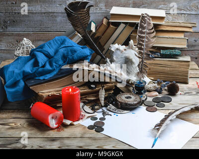 Libri antichi, inchiostro, piume su uno sfondo di legno. Close up. Messa a fuoco selettiva. Foto Stock