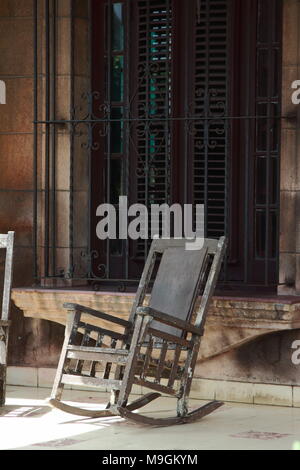 Una sedia a dondolo su una veranda soleggiata nel centro di Avana, Cuba. Foto Stock