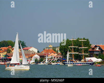 Barche sul lago Mikolajskie, townscape di Mikolajki in background. Masurian Distretto dei Laghi. Provincia Warmian-Masurian, Polonia. L'Europa. Foto Stock