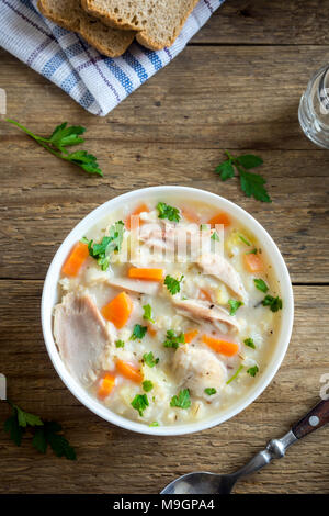 Pollo e riso selvatico zuppa. In casa fresca zuppa cremosa con pollo e verdure e riso selvatico nella ciotola bianco vicino. Foto Stock