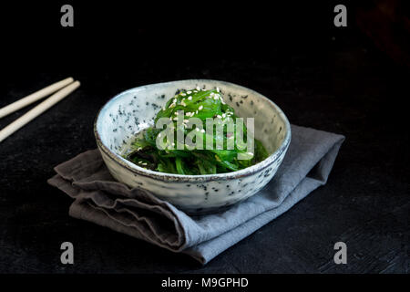 Chuka Insalata di alghe marine in vaso in ceramica su sfondo nero, copia dello spazio. La cucina giapponese - Insalata Chuka Foto Stock