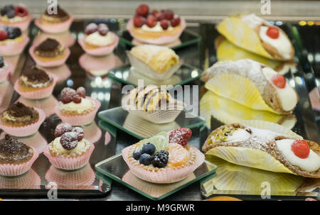 Ampia selezione di dolci e torte sul display in vetro frigorifero espositore all'interno italiano ristorante cafe, Roma, Italia Foto Stock