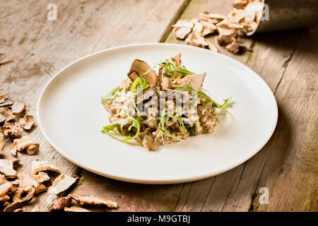 Risotto ai funghi su un tavolo di legno Foto Stock