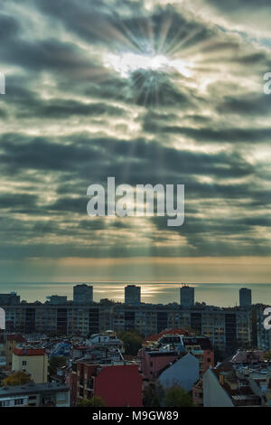 Sunray sopra il Mar Nero a Varna , edificio della città in primo piano. Foto Stock