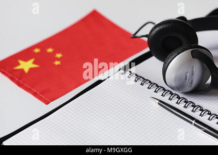 L apprendimento delle lingue straniere. Blocco note per voci e una bandiera. Lang Foto Stock