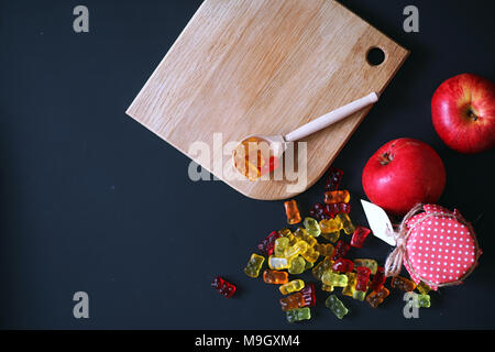 La marmellata di arance in un vaso sul tavolo. Caramelle in una ciotola su una ba nero Foto Stock