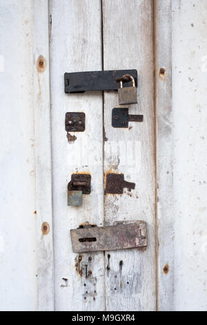 Porta bianca con una vecchia serratura con tracce di blocchi precedenti su di esso Foto Stock