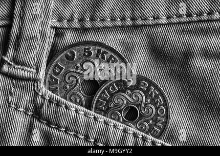 La Danimarca denominazione di monete è di 5 e 2 krone (crown) nella tasca del vecchio jeans denim, girato in bianco e nero. Foto Stock