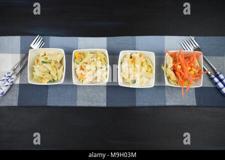 Laici piatta con una linea di piatti di insalata di pasta Foto Stock