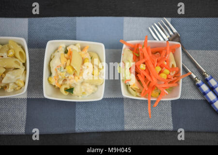 Laici piatta con una linea di piatti di insalata di pasta Foto Stock