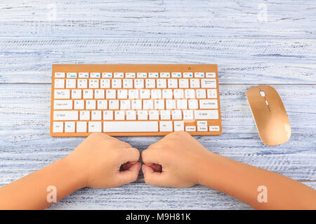 Vista dall'alto in mani femminili nei pressi di oro wireless tastiera e mouse Foto Stock