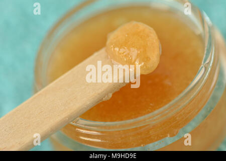 Macro di labbro in casa scrub fatti di zucchero di canna, miele e olio d'oliva in un vasetto di vetro Foto Stock