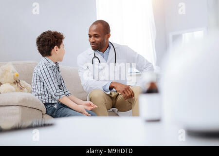 Fiducioso medico maschio e ragazzo comunicante Foto Stock