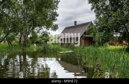 Incredibile vista sulla cabina solitario vicino al lago tra gli alberi. Foto Stock