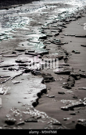 Una spiaggia surgelati, parzialmente coperta da ghiaccio a costa del Mar Baltico. Foto Stock