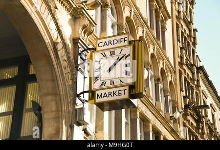 Un grande orologio tradizionale con numeri romani sull'esterno dell'edificio di mercato nel centro della città Foto Stock