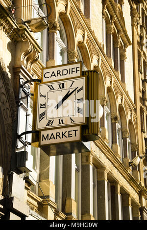 Un grande orologio tradizionale con numeri romani sull'esterno dell'edificio di mercato nel centro della città Foto Stock