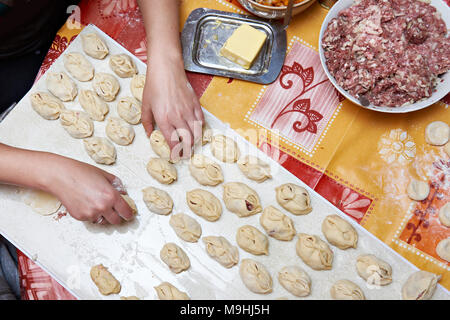 Preparazione di carne gnocchi con carne tritata sul tavolo della cucina Foto Stock