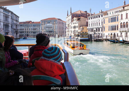 I passeggeri di prima persona POV su un vaporetto vaporetto viaggia verso il basso il Grand Canal, Venezia, Italia verso Università Ca' Foscari con un taxi acqueo p Foto Stock