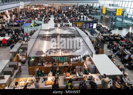 Aeroporto di Heathrow Terminal 5 sala partenze e concourse. Grande mappa del mondo sul tetto di Starbucks in uscita. Occupato con i passeggeri in un giorno di molti fli Foto Stock