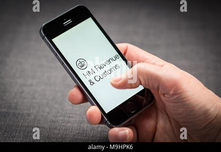 Un uomo utilizzando l'HMRC HM Revenue e dogana app su un iPhone NEL REGNO UNITO Foto Stock