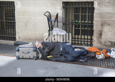 Senzatetto uomo dorme sulla strada a midtown Manhattan, New York. Foto Stock