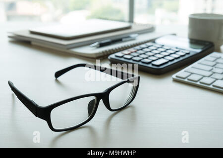 Close up di bicchieri e computer business sul posto di lavoro posto di lavoro in ufficio Foto Stock