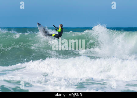 Un surfista eseguendo una spettacolare trucco nella parte superiore di una forma d'onda a Fistral in Newquay Cornwall. Foto Stock