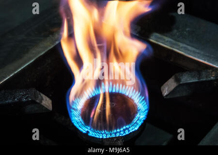 Combustione di gas nel bruciatore del forno a gas. grandi fiamme di fuoco. Fiamme Gialle vicino fuoco pesanti dalla stufa Foto Stock