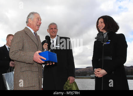 Il Principe di Galles è presentato con un cristallo di pennini tumbler da direttore non esecutivo di Lucinda Langton di Ullswater vaporizzatori in società in Glenridding, Cumbria a bordo della loro nave ammiraglia signora del lago, durante una visita alla zona per contrassegnare il Lake District riceve Sito Patrimonio Mondiale lo stato. Foto Stock