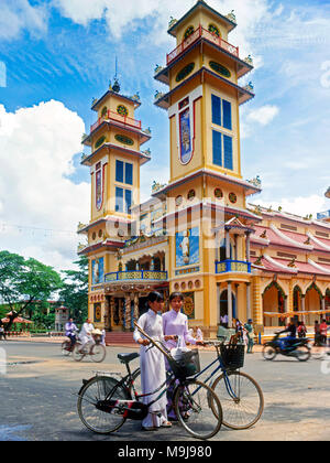 Il vietnamita ragazze con le biciclette, Cao Dai, Cattedrale di Tay Ninh, Vietnam del sud Foto Stock