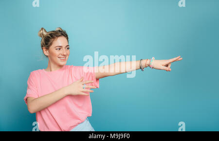 Moderno e giovane donna di puntamento spazio copia e sorridente Foto Stock