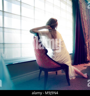 Donna seduta in una stanza Foto Stock