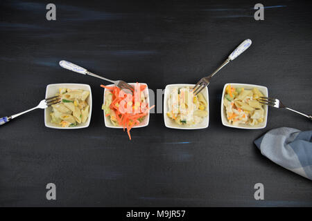 Laici piatta con una linea di piatti di insalata di pasta Foto Stock