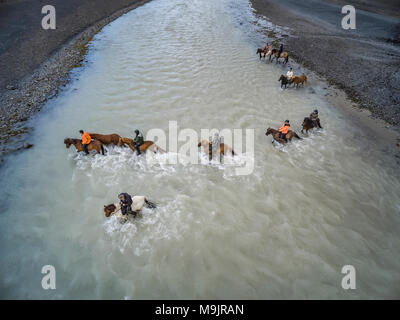 Cavalli Farid Attraversamento fiume glaciale vicino ghiacciaio Hagafellsjokull, Islanda Foto Stock