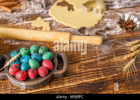 Ancora in vita su un sfondo di legno con insolitamente colorati uova di quaglia e forme per la cottura in forno di parentesi i cookie per la Pasqua. Foto Stock