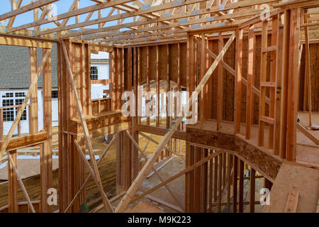 Una vista interna di una nuova casa in costruzione con cablaggio esposto e e una scaletta sul pavimento. Inquadratura orizzontale. Foto Stock