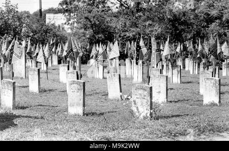 Bandiere di ribelli adornano i marcatori di grave in un confederato cimitero in Georgia, ca. 1952. Foto Stock