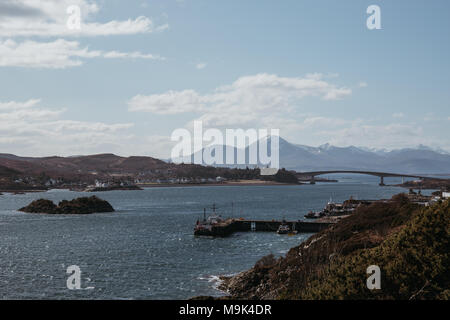 Vista di Skye Bridge e un piccolo villaggio costiero sull isola di Skye in Scozia, in una giornata di sole. Vista da Kyle of Lochalsh. Foto Stock