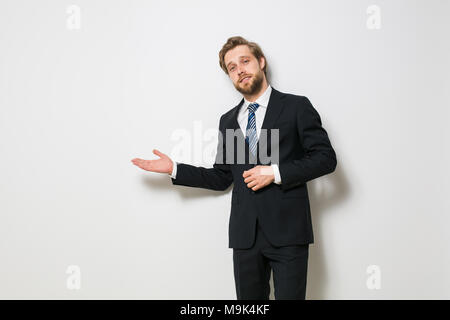 Fiducioso uomo pronto per concludere un business o un contratto, presentando uno dei lati o sia come una scelta, una bionda con barba in elegante costume Foto Stock