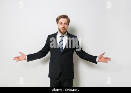 Fiducioso uomo pronto per concludere un business o un contratto, presentando uno dei lati o sia come una scelta, una bionda con barba in elegante costume Foto Stock