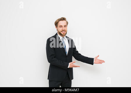 Fiducioso uomo pronto per concludere un business o un contratto, presentando uno dei lati o sia come una scelta, una bionda con barba in elegante costume Foto Stock