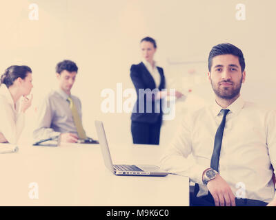 Ritratto di giovane arabo moderno business man con la barba in ufficio, gruppo di gente di affari sulla riunione rendendo la presentazione in background Foto Stock