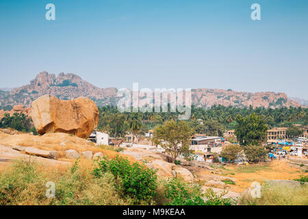 Stone Mountain e palme, centro storico scenario in Hampi, India Foto Stock