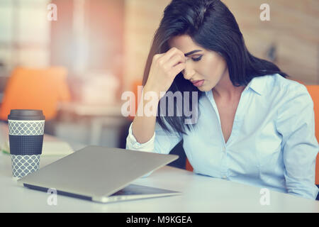 I giovani occupati latino bella donna d'affari di sofferenza lo stress lavorando al computer di ufficio Foto Stock
