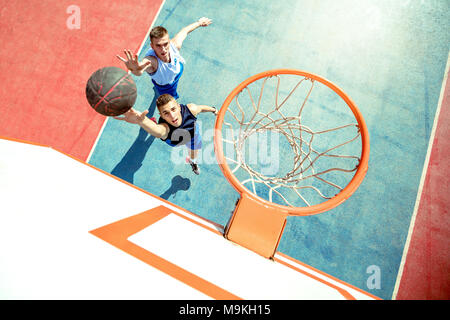 Angolo di alta vista del giocatore di basket dunking basket in hoop Foto Stock