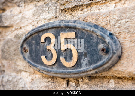 Il numero trenta cinque su una placca di ferro su una home per mostrare le proprietà indirizzo Foto Stock